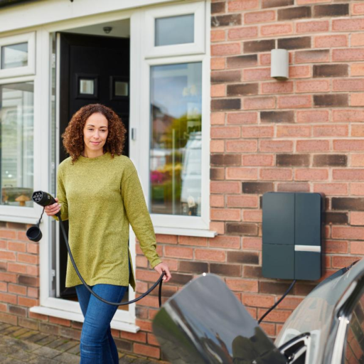 Free stock photo of a homeowner charging an electric vehicle outside a house