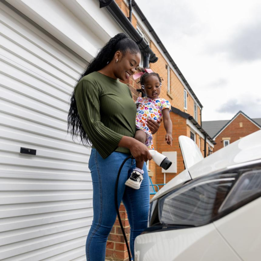 Family charging an electric car outside a home