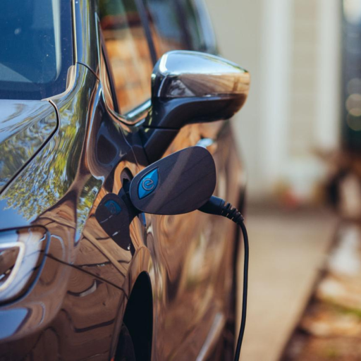 Close-up of an electric vehicle plugged into a home charger